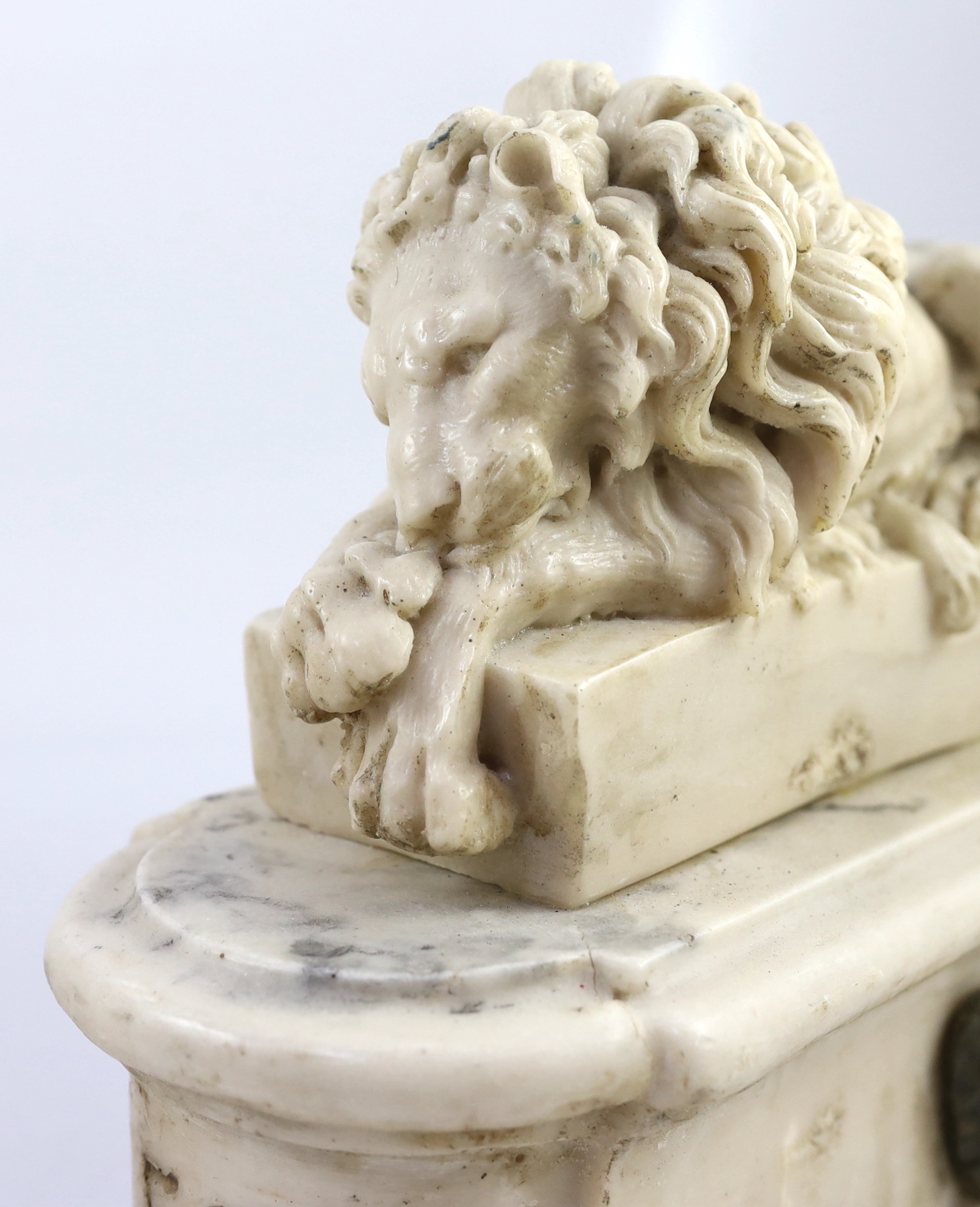 After the Antique. A pair of marble resin models of the Medici lions, each seated upon an oblong plinth, applied with bronze masks, inscribed LECXX, 41cm long, 15cm deep, 29cm high